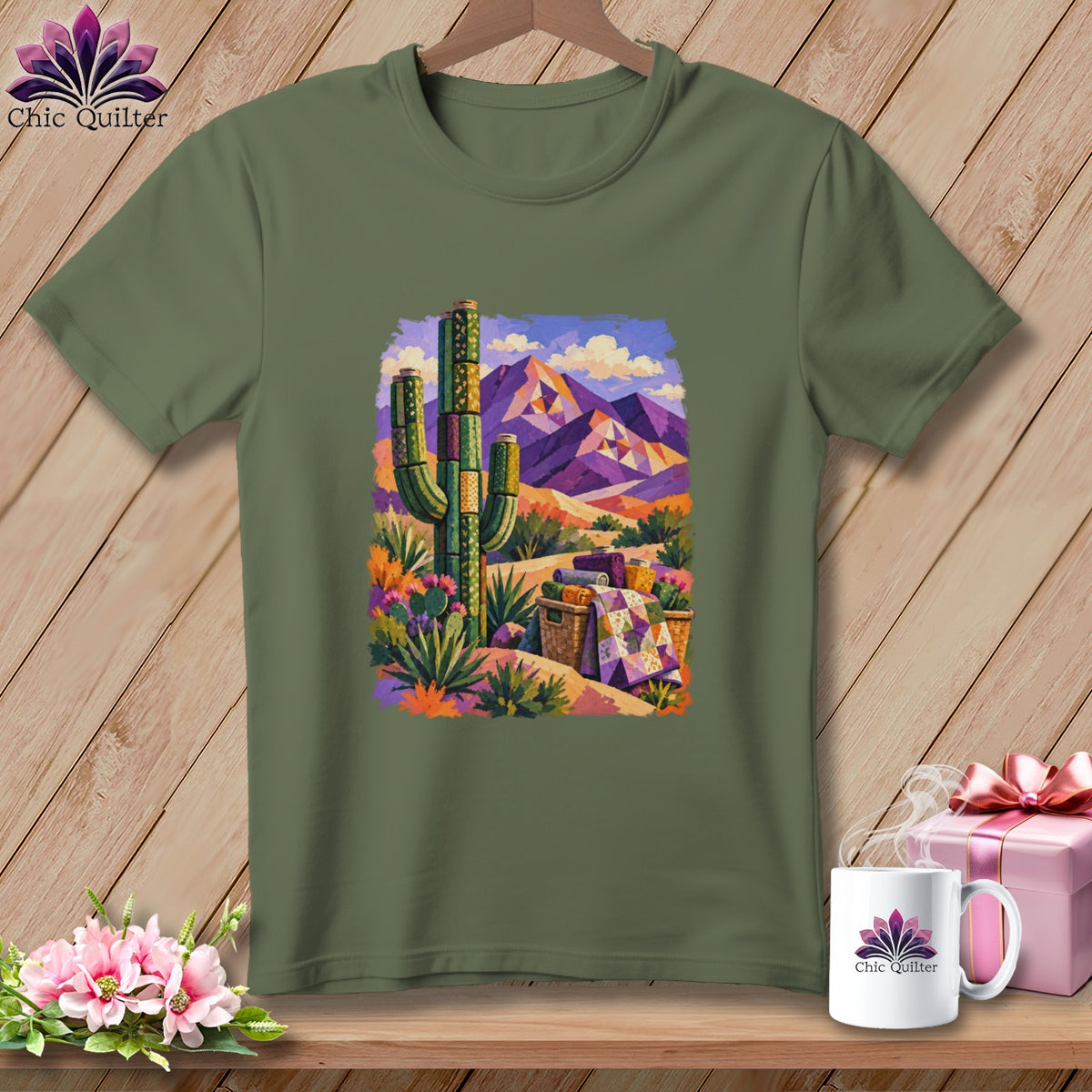 An olive green t-shirt with a colorful desert scene graphic featuring a cactus and purple mountains.