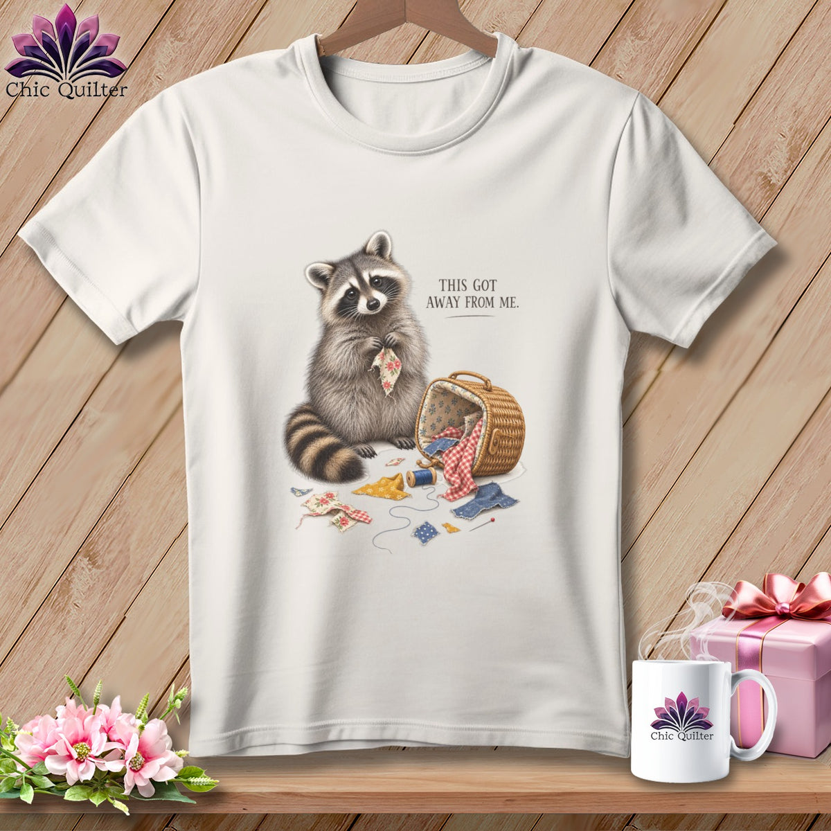 White t-shirt graphic with raccoon and sewing supplies, text reads "THIS GOT AWAY FROM ME."
