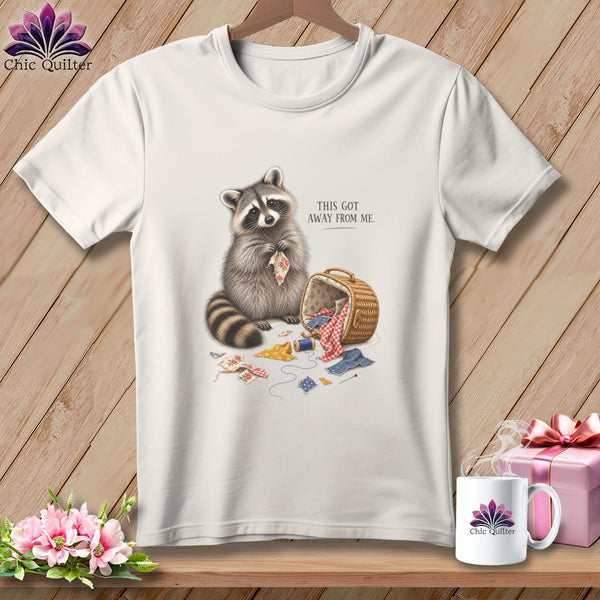White t-shirt graphic with raccoon and sewing supplies, text reads "THIS GOT AWAY FROM ME."