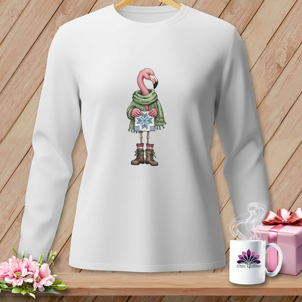 White long-sleeve shirt with a cartoon flamingo wearing a scarf, boots, and holding a gift.