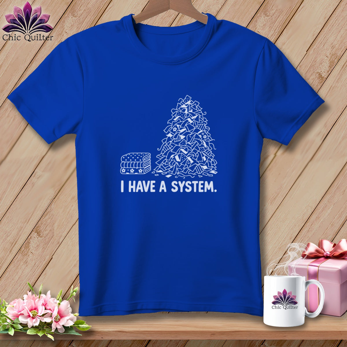 Blue t-shirt with stacked fabric and chaotic fabric pile graphic and text "I HAVE A SYSTEM."
