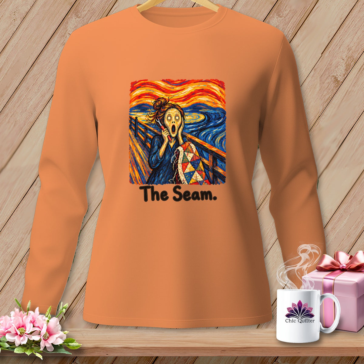 Orange long-sleeve shirt with "The Seam" graphic featuring Edvard Munch's "The Scream" and a quilt.