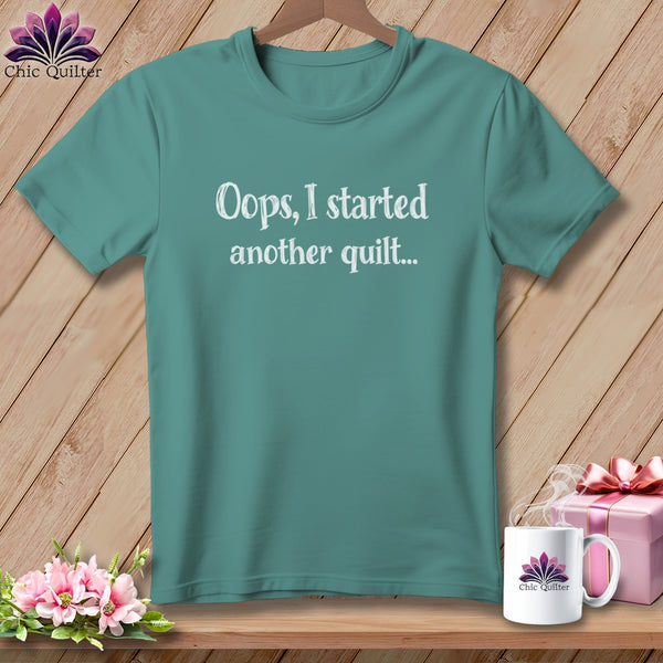 Teal t-shirt with white text "Oops, I started another quilt..."