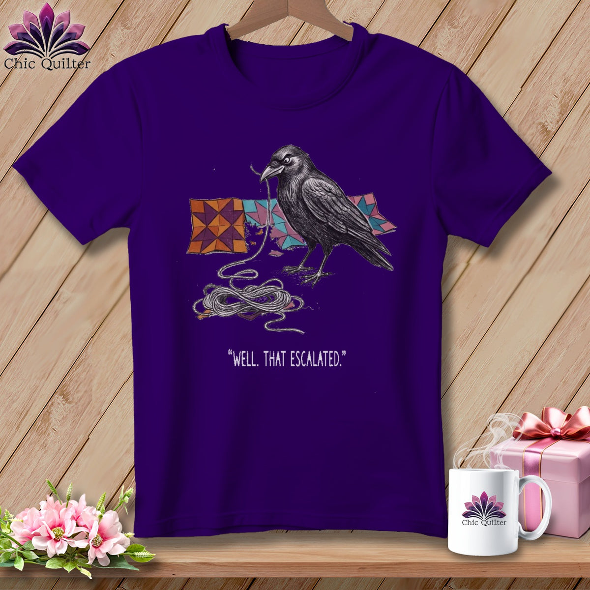 Purple t-shirt with a crow tangled in string and quote "Well, That Escalated."