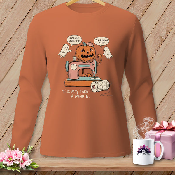 Halloween pumpkin and ghost with sewing machine and text "This may take a minute".