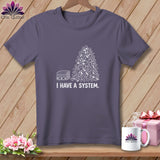 Purple t-shirt with a drawing of neatly folded fabric and a pile of fabric scraps with 