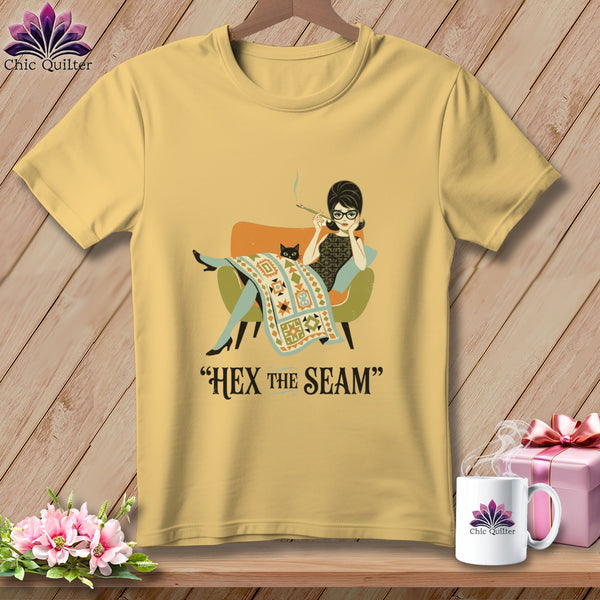 Yellow t-shirt with graphic of woman and cat with text "HEX THE SEAM"