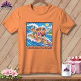 Orange t-shirt featuring a graphic of three women surfing on a patchwork quilt, with the text Catch the Wave, Piece the Quilt.