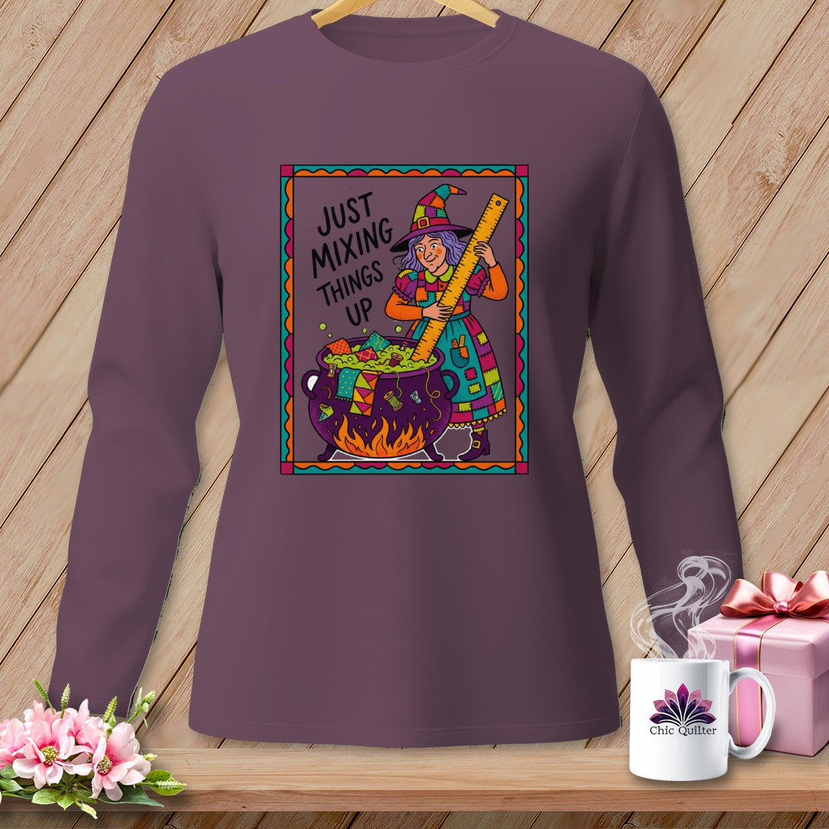 Illustration of a witch stirring a cauldron with a ruler on a purple long-sleeved shirt.