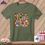 Olive green t-shirt featuring cartoon farm animals peeking over a colorful patchwork quilt.