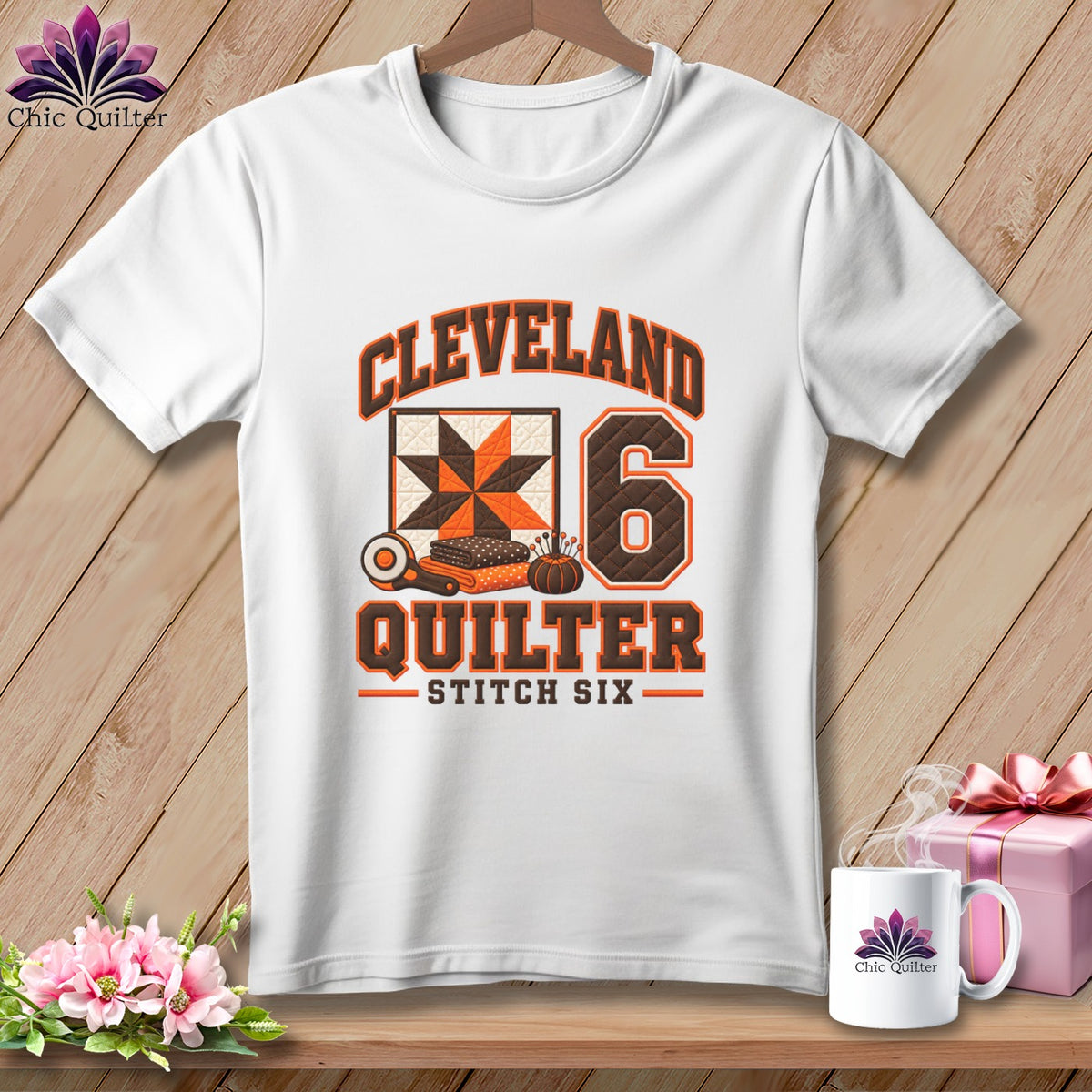 A white t-shirt features a Cleveland Quilter graphic with a quilt block and rotary cutter.