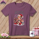 Plum short-sleeve t-shirt with a graphic of an older woman in a Santa hat holding a mug.