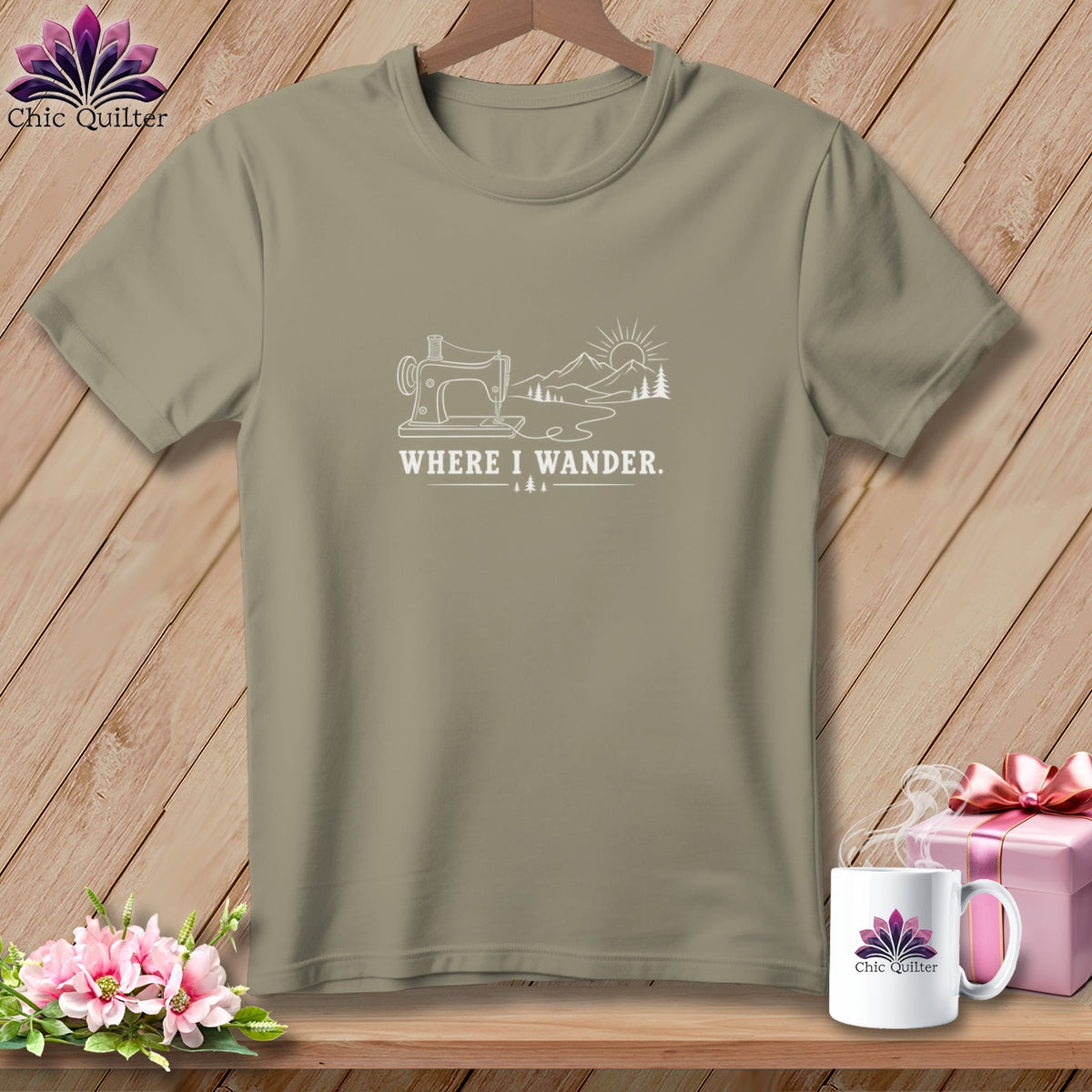 Taupe t-shirt with sewing machine, mountains, and "WHERE I WANDER." text graphic.