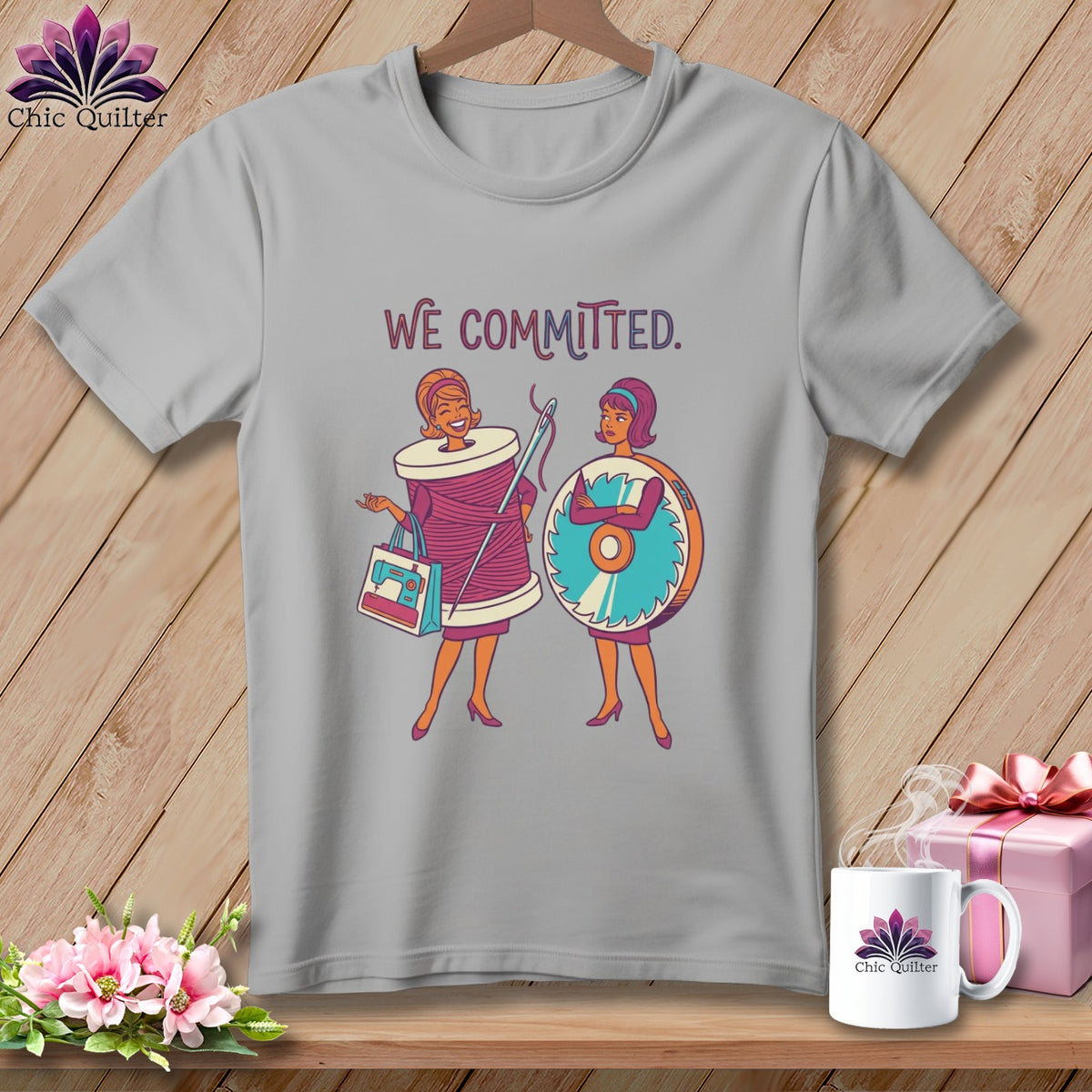 Gray t-shirt with "WE COMMITTED." text and cartoon quilters with sewing supplies.