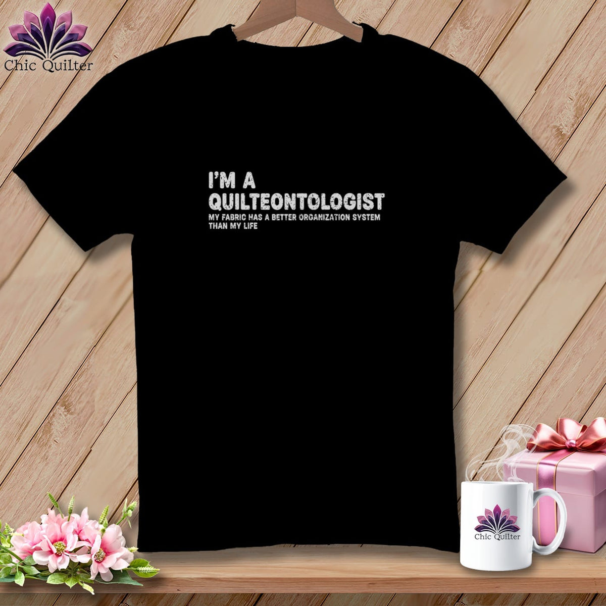 Black t-shirt with "I'M A QUILTEONTOLOGIST" and "MY FABRIC HAS A BETTER ORGANIZATION SYSTEM THAN MY LIFE" text.