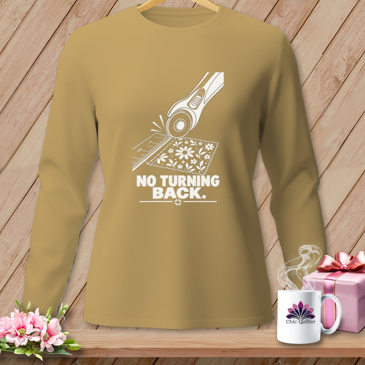 Tan long-sleeve shirt with rotary cutter on floral fabric and text "NO TURNING BACK."
