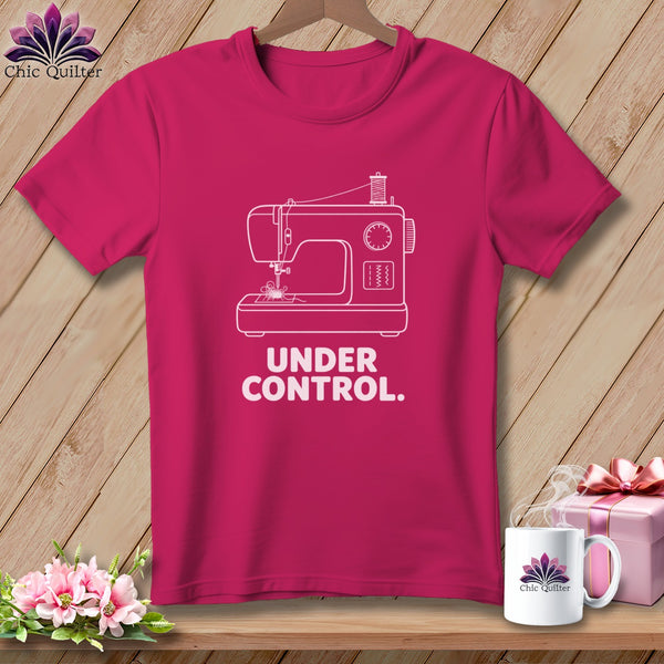 Pink t-shirt with white sewing machine graphic and text "UNDER CONTROL.".