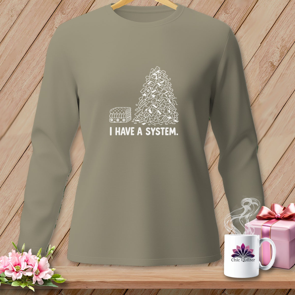 Long-sleeve shirt with a stack of fabrics and a pile of fabric scraps with "I HAVE A SYSTEM" text.
