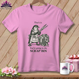 Pink t-shirt with drawing of a penguin holding scissors over a basket of fabric scraps.