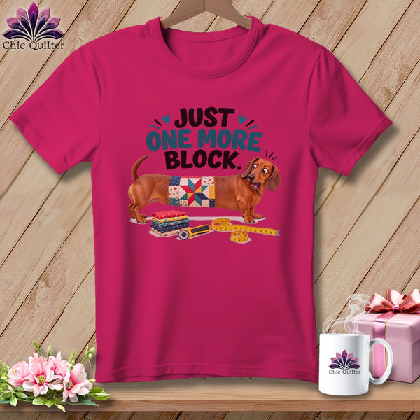 Dachshund wearing a quilt block with text "Just One More Block."