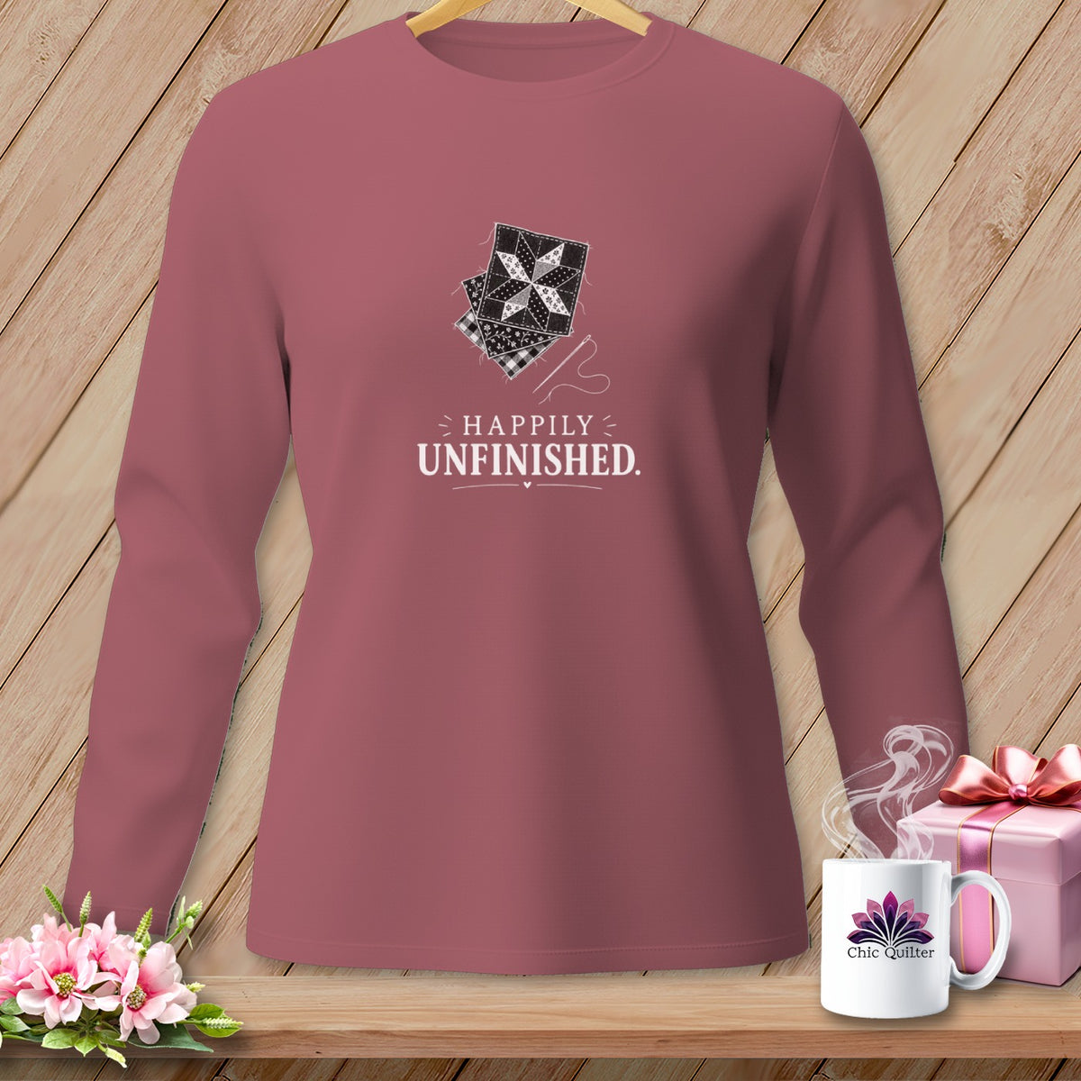 Long-sleeve shirt with "Happily Unfinished" text and quilting designs.