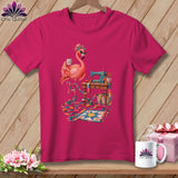 Pink t-shirt with a flamingo at a sewing machine with a quilt and supplies.