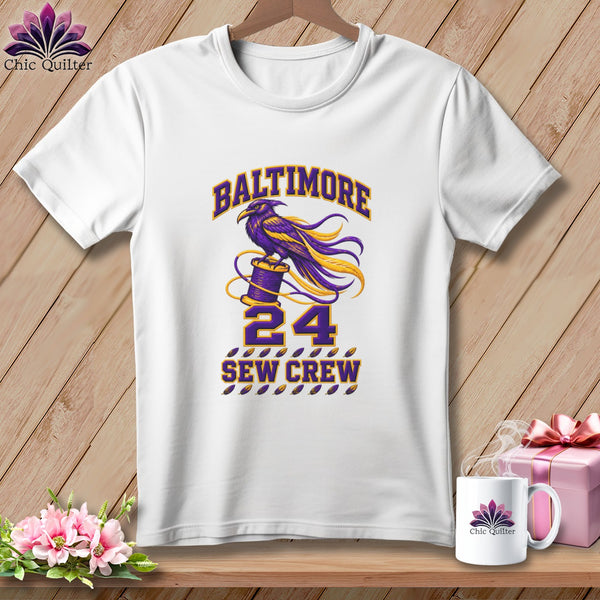 A white t-shirt featuring a purple and gold Baltimore Sew Crew 24 raven design.