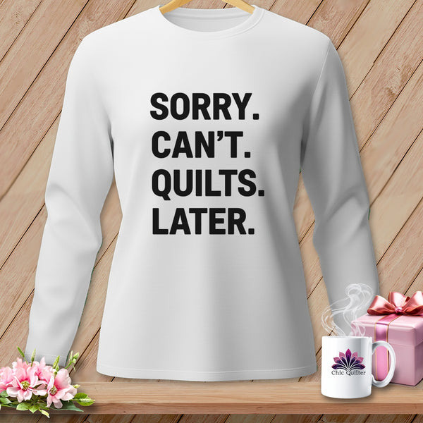 White long-sleeved shirt with "SORRY. CAN'T. QUILTS. LATER." printed on the front.