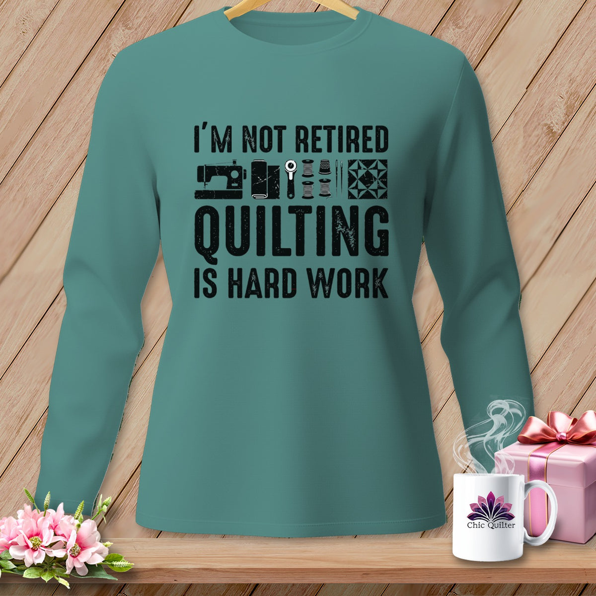 Teal long-sleeve shirt with "I'm not retired quilting is hard work" text and sewing graphics.