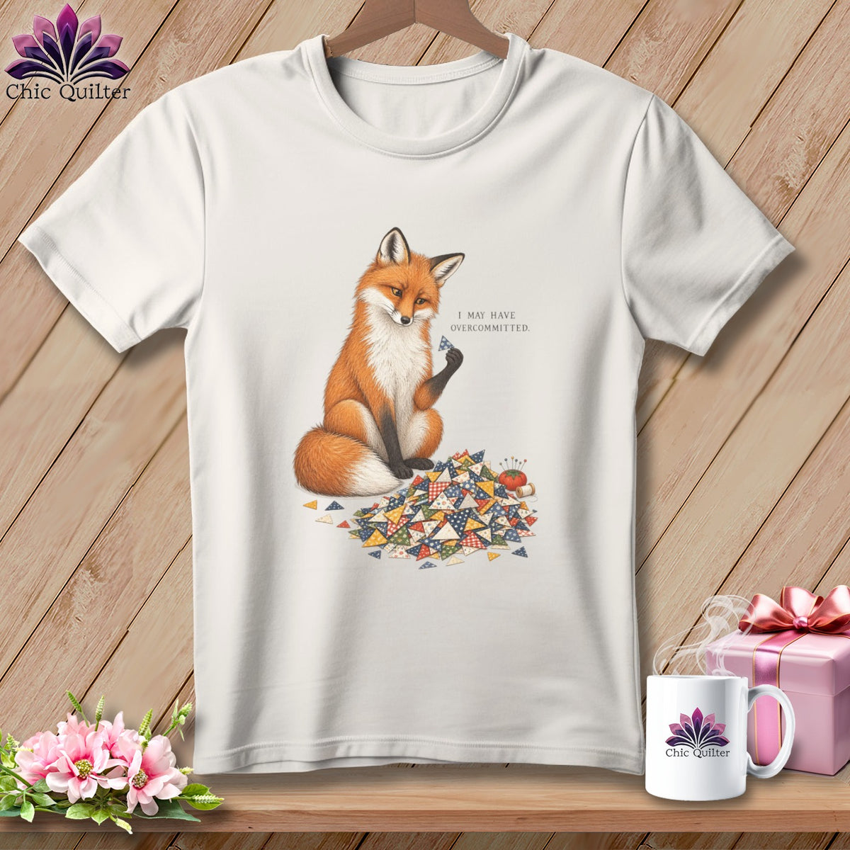 White t-shirt with a fox sitting amongst quilting scraps, text reads "I MAY HAVE OVERCOMMITTED."