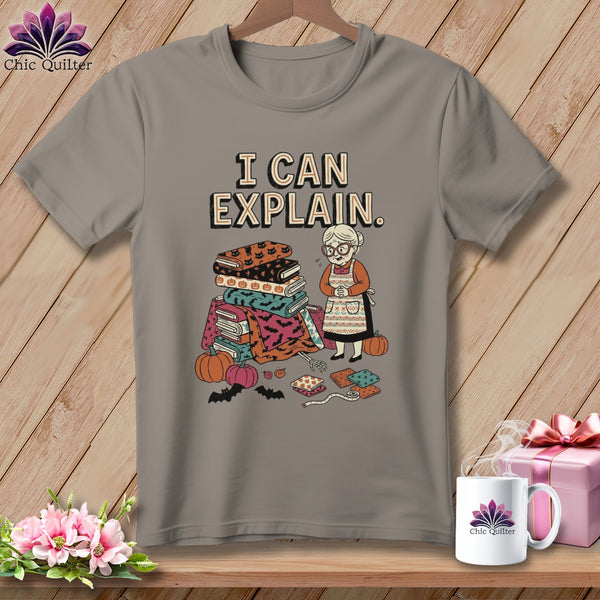 Gray t-shirt with "I Can Explain" text and illustration of a quilter with Halloween-themed fabrics.