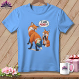 Light blue t-shirt with two cartoon foxes, one with a quilted tail patch, and a speech bubble saying 