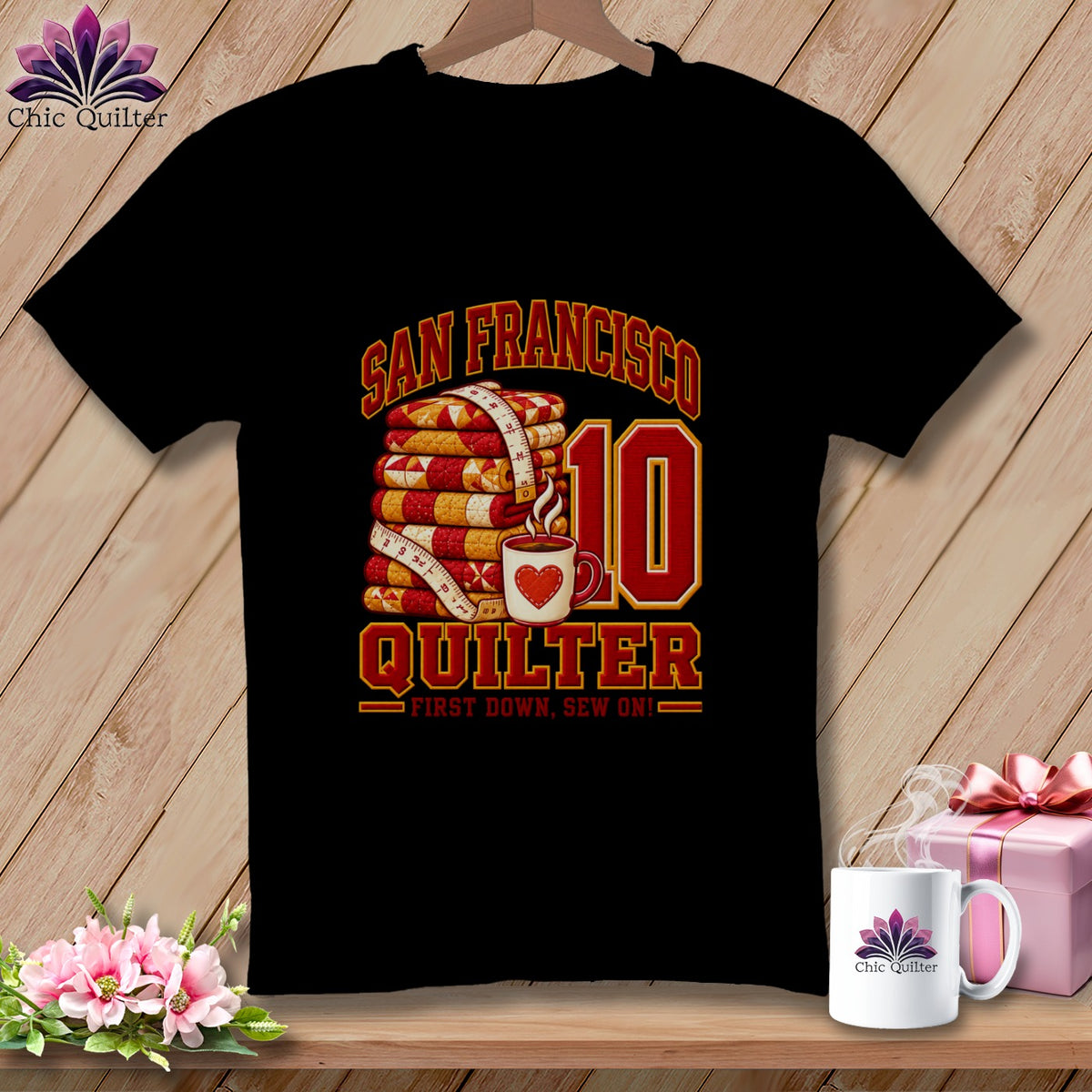 A black t-shirt with a graphic reading San Francisco Quilter First Down Sew On with stacked quilts, a coffee mug, and the number ten.