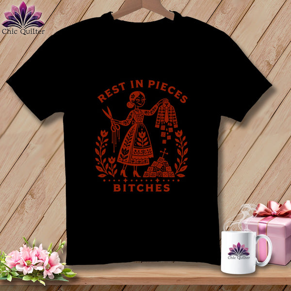 Black t-shirt with red graphic of woman holding scissors and fabric, text reads "Rest in Pieces Bitches".