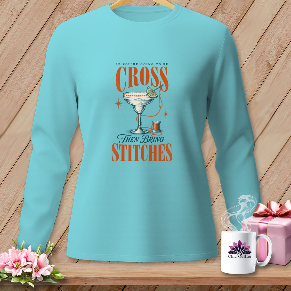 Light blue long-sleeve shirt with "If You're Going To Be Cross Then Bring Stitches" graphic.