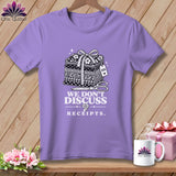 Purple t-shirt with a graphic of fabric stacks, scissors, and text 