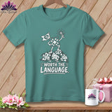 Teal t-shirt with a graphic of a quilt square character holding a flag and a sun, standing on broken quilt squares.