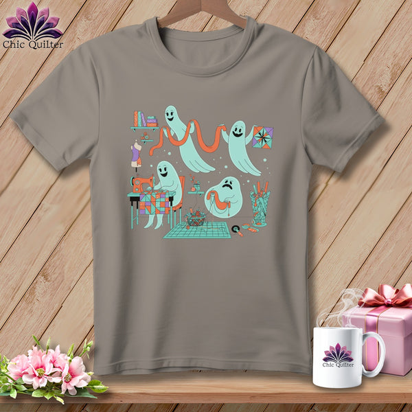 Gray t-shirt with cartoon ghosts sewing and quilting on a wooden background.