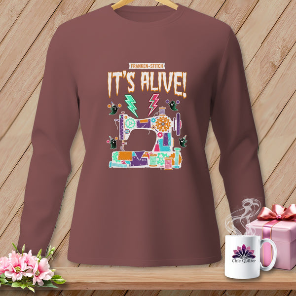 Franken-stitch "It's Alive!" graphic on a long-sleeve shirt featuring sewing machine, ghosts, and lightning.