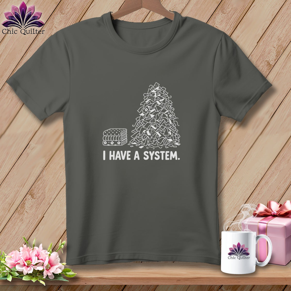 Dark grey t-shirt with white graphic of stacked fabric and scraps, reads "I HAVE A SYSTEM."