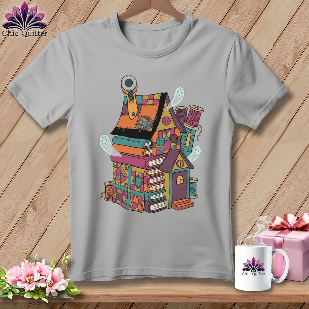 Gray t-shirt with a colorful illustrated house made of books, spools, and ghosts.