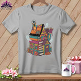 Gray t-shirt with a colorful illustrated house made of books, spools, and ghosts.