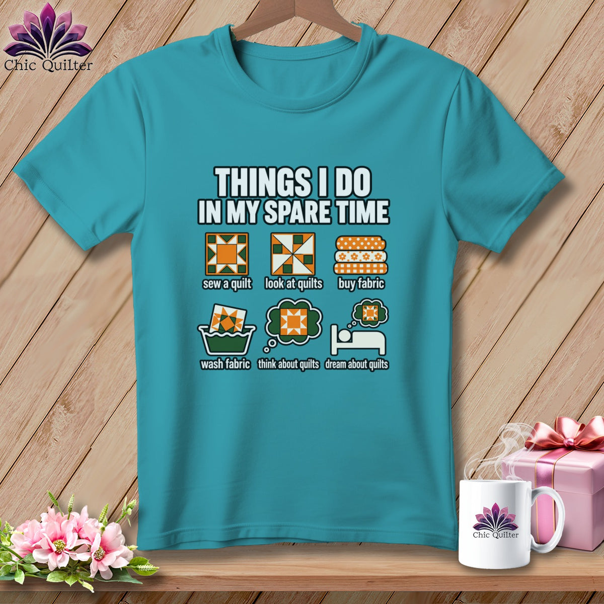 Teal t-shirt featuring humorous quilting graphics and text hanging against a wooden wall.