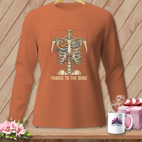 Skeleton ribcage filled with colorful fabric rolls and a pumpkin, text "FABRIC TO THE BONE".