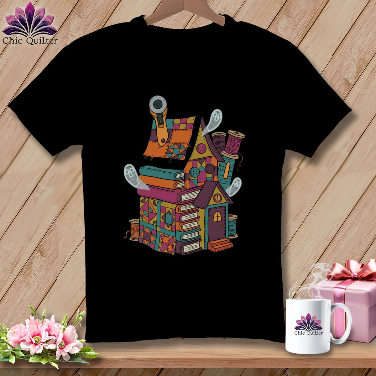 Black t-shirt featuring a colorful sewing-themed house with ghosts and books.