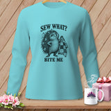 A light blue long-sleeved shirt featuring a graphic of a hedgehog holding a quilt with text reading SEW WHAT BITE ME.