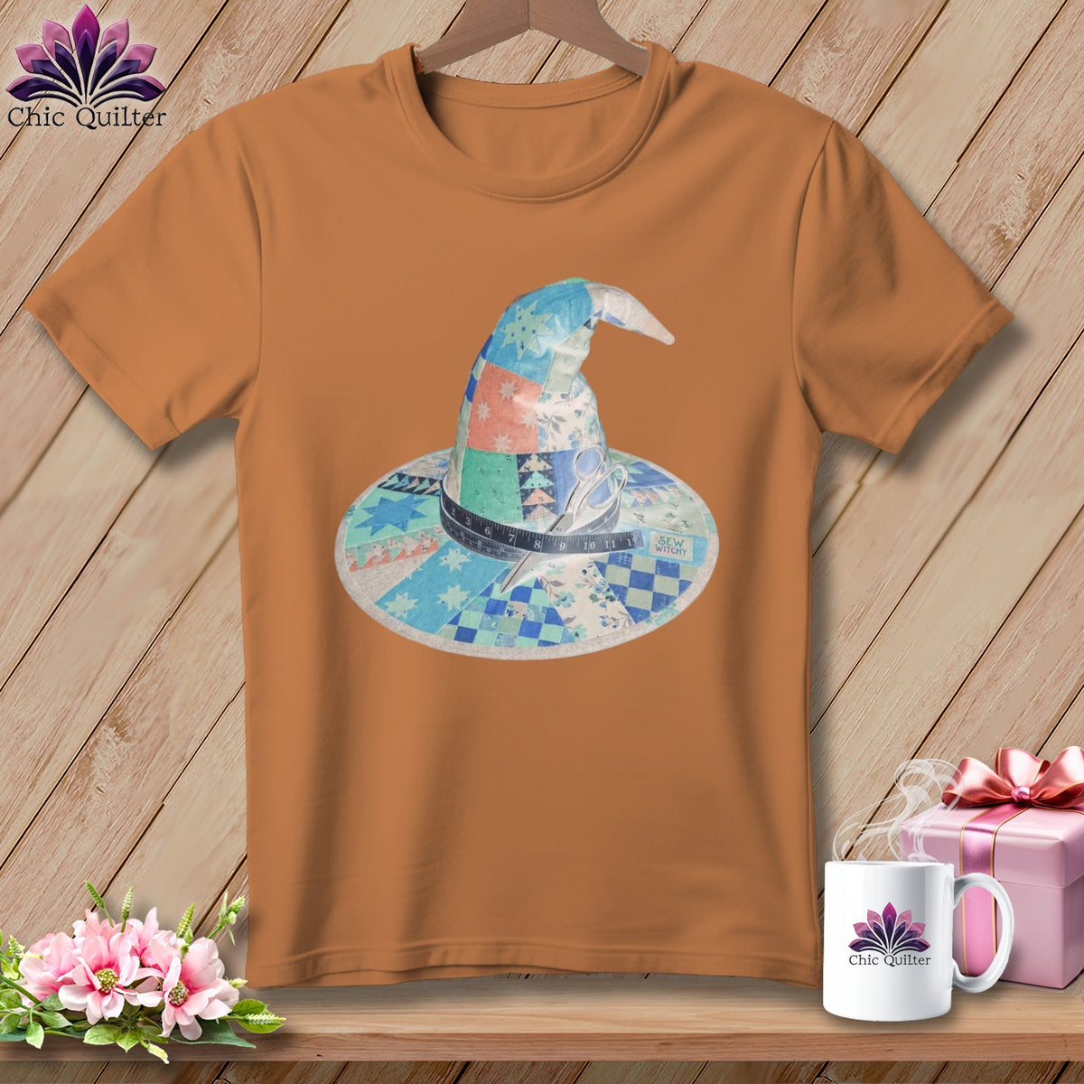 Orange t-shirt with a quilted witch hat design featuring scissors and a measuring tape.