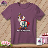 Plum crewneck t-shirt featuring a superhero duck holding a rotary cutter and quilt block with the text We Cut at Dawn.