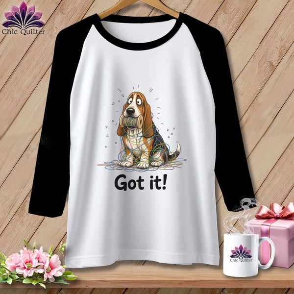 T-shirt with a cartoon basset hound entangled in colorful yarn, saying "Got it!".